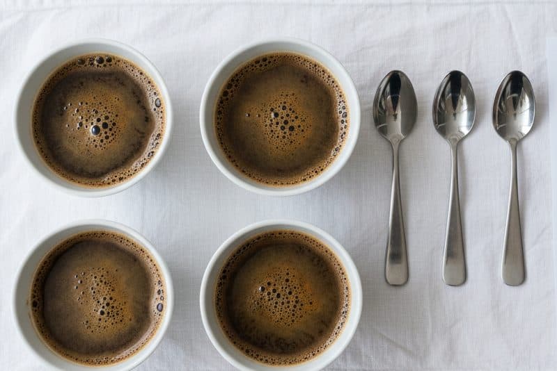 Four cupping bowls and spoons laid out on a white cloth